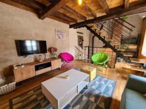 a living room with a white table and a tv at À louer : Ancienne forge avec sauna, piscine, proche plage et sites historiques - FR-1-591-193 in Le Menoux