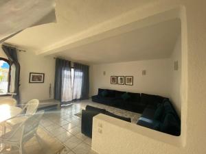 a living room with a black couch and a table at Jawhara Smir - Appartements, Piscine & Plage in M'diq