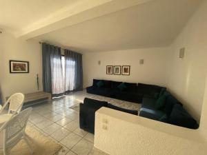 a living room with a couch and a table and chairs at Jawhara Smir - Appartements, Piscine & Plage in M'diq