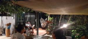 un groupe de personnes assises autour d'une pièce avec un homme assis sur une chaise dans l'établissement บ้านลูกจัน Bann Lookjan Trat, à Trat