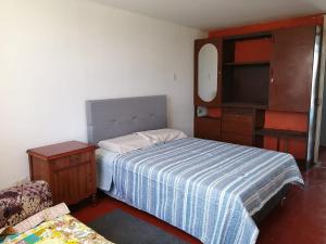1 dormitorio con 1 cama, vestidor y TV en Habitación Privada en casa familiar, en Zamacola