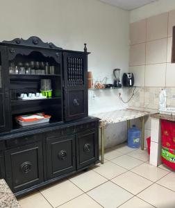 a kitchen with a large black cabinet in a room at Casa Sítio Beija Flor in Guaramiranga
