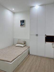 - une chambre blanche avec un lit et un placard dans l'établissement Ocean Sweet Home, à Hanoï