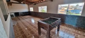 an empty room with a table in a room with windows at Casa com piscina e lazer em SBC SP in São Bernardo do Campo