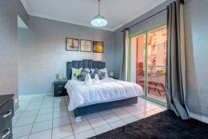 um quarto com uma cama e uma porta de vidro deslizante em Grand Cozy Apartment in Heart of Hivernage em Marrakech