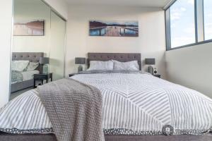 Un dormitorio con una cama grande y un espejo. en Mod Brisbane Apt near Southbank W Pool & Parking, en Brisbane 19 fotos más