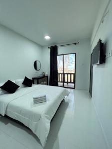 a white bedroom with a large bed and a large window at Chalet Barokah Resort, Bachok in Bachok