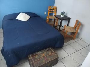 ein Schlafzimmer mit einem Bett, einem Tisch und einem Stuhl in der Unterkunft Departamento centrico in San Juan del Río