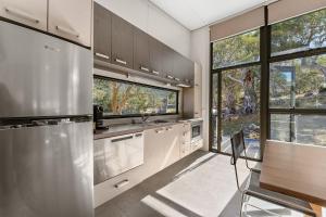 a kitchen with stainless steel appliances and a large window at Ecocrackenback Chalet 18 in Crackenback