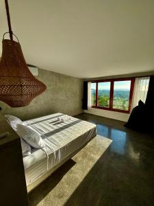 a bedroom with a bed and a large window at Padawatu Villas in Uluwatu