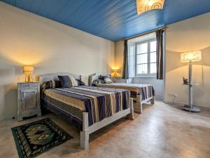 2 Betten in einem Schlafzimmer mit blauer Decke in der Unterkunft Gîte Yssingeaux, 4 pièces, 6 personnes - FR-1-582-144 in Yssingeaux