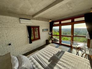 a bedroom with a bed and a large window at Padawatu Villas in Uluwatu