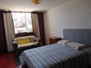 sypialnia z łóżkiem, krzesłem i oknem w obiekcie Habitación Privada con baño privado w mieście Zamacola