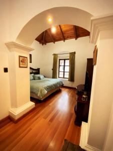 a bedroom with a bed in a room with a wooden floor at Indian Palace Hotel Boutique Spa & Restaurante in Antigua Guatemala