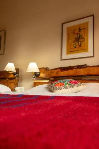 a bedroom with two beds with a red blanket at Almawasi Lodge in Yungay