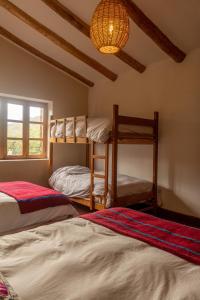 een slaapkamer met 2 stapelbedden en een kroonluchter bij Almawasi Lodge in Yungay