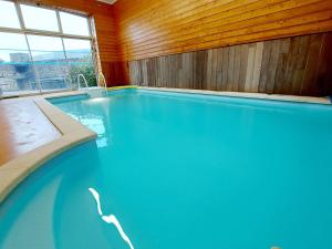 a swimming pool with blue water in a wooden wall at Gîte Carelles, 5 pièces, 11 personnes - FR-1-600-57 in Carelles