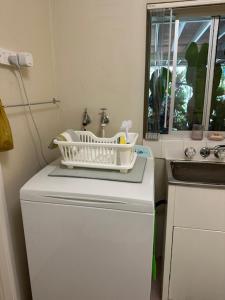 a small kitchen with a refrigerator and a sink at The singing frogs studio in Coffs Harbour