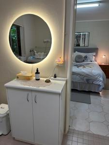 a bedroom with a bed and a mirror and a counter at The singing frogs studio in Coffs Harbour