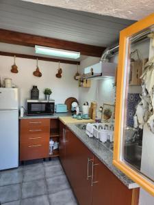 cocina con armarios marrones y nevera blanca en Refúgio de Velada - Nisa, en Nisa