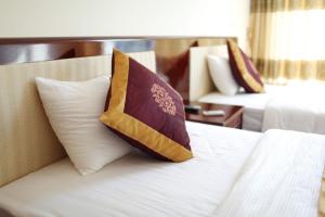 um quarto de hotel com uma cama com uma almofada em Agri Hotel Điện Biên Phủ - by Bay Luxury em Dien Bien Phu