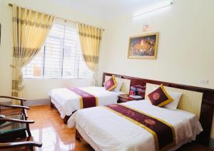 1 dormitorio con 2 camas y ventana en Agri Hotel Điện Biên Phủ - by Bay Luxury, en Diện Biên Phủ