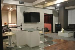 Kanie的住宿－HOTELウォーターゲート蟹江（カップル専用），客厅设有酒吧和平面电视。