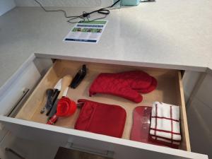 un cajón en un escritorio con manoplas rojas y tijeras en Briarcliff Oasis, en Atlanta