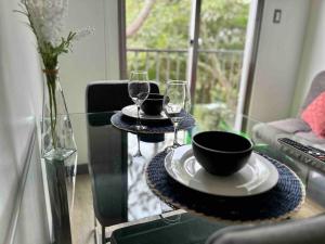 Luxury Loft, El Dorm 322. في غواتيمالا: طاولة زجاجية مع طبقين وكؤوس للنبيذ