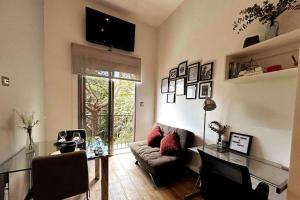 Luxury Loft, El Dorm 322. في غواتيمالا: غرفة معيشة مع أريكة وطاولة زجاجية