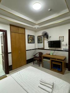 a living room with a television and a desk with towels at Hoàng Thiên Lộc Hotel -199 Hoàng Hoa Thám, Q. Tân Bình - by Bay Luxury in Ho Chi Minh City