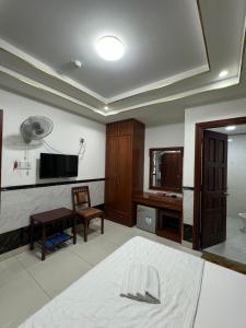 Schlafzimmer mit einem Bett, einem Tisch und einem TV in der Unterkunft Hoàng Thiên Lộc Hotel -199 Hoàng Hoa Thám, Q. Tân Bình - by Bay Luxury in Ho-Chi-Minh-Stadt