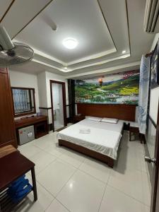ein Schlafzimmer mit einem Bett und einem Wandgemälde in der Unterkunft Hoàng Thiên Lộc Hotel -199 Hoàng Hoa Thám, Q. Tân Bình - by Bay Luxury in Ho-Chi-Minh-Stadt