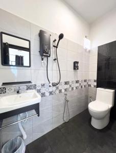 a bathroom with a toilet and a sink at Chalet Barokah Resort, Bachok in Bachok