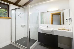 a bathroom with a sink and a glass shower at Chandlers Smiths Beach Villas in Yallingup
