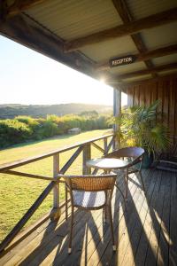 a porch with two chairs and a table on it at Chandlers Smiths Beach Villas in Yallingup