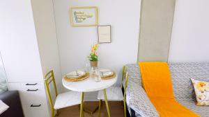 uma pequena mesa e cadeiras num pequeno quarto com uma cama em Peace & Elegance in downtown MTL em Montreal