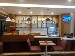 a restaurant with a counter and chairs and a table at Manise Hotel in Ambon