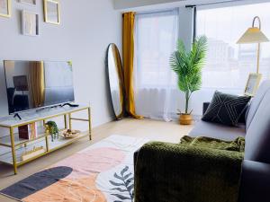 uma sala de estar com um sofá e uma televisão em Peace & Elegance in downtown MTL em Montreal
