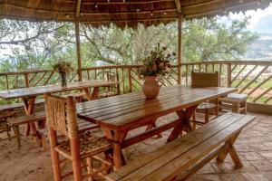 a wooden table with chairs and a vase on it at Almawasi Lodge in Yungay