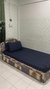 a bed in a room with a blue mattress at Homestay Taman Bahagia in Tenom