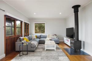 a living room with a couch and a tv at Strong Farmers Cottage Willunga in Willunga