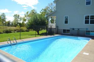 a swimming pool in front of a house at Old Town Country Landing in Niagara-on-the-Lake