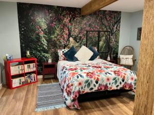 una camera con un letto e un'ampia parete floreale di Cottonwood#2 a Youbou