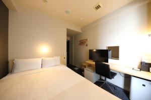 a hotel room with a bed and a desk at Smile Hotel Kyoto Karasuma Gojo in Kyoto