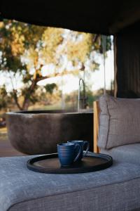 a blue coffee cup on a table with a tub at Serenità Stanthorpe in Severnlea