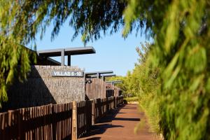 a fence with a sign on it next to a road at Chandlers Smiths Beach Villas in Yallingup