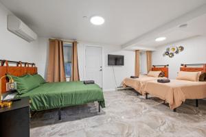 1 dormitorio con 2 camas con sábanas verdes y TV en Upper East Side Luxury 3BR 2B, en Nueva York
