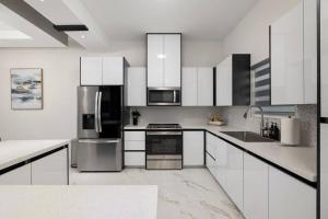 a kitchen with white cabinets and stainless steel appliances at Quinta Real 4909 in McAllen