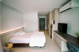 una camera d'albergo con letto e TV di BaanTip​ HomeStay a Amphoe Phra Khanong